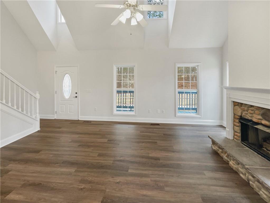185 Thrasher Lane Jasper, GA 30143 - Photo 7 of 32 an empty room with wooden floor fireplace and windows