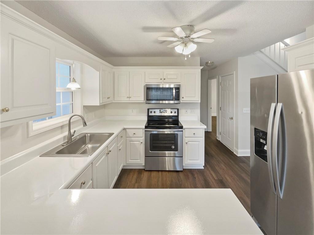 185 Thrasher Lane Jasper, GA 30143 - Photo 10 of 32 a kitchen with a refrigerator sink and white cabinets