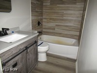 6439 Wadsworth Road Medina, OH 44256 - Photo 9 of 14 Bathroom featuring shower / bathtub combination, vanity, and dark wood finished floors
