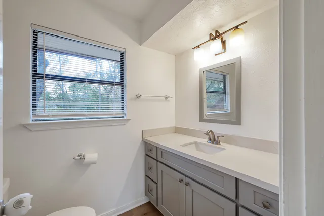 a bathroom with a sink mirror vanity and a toilet