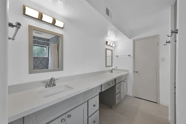 a bathroom with a granite countertop sink two mirror and a