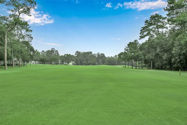 a view of a green field with wooden fence