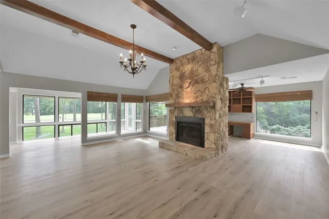 a view of empty room with wooden floor and fireplace