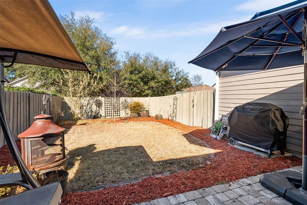 7638 Southwest 80th Drive Gainesville, FL 32608 - Photo 34 of 48 a backyard of a house with barbeque oven table and chairs
