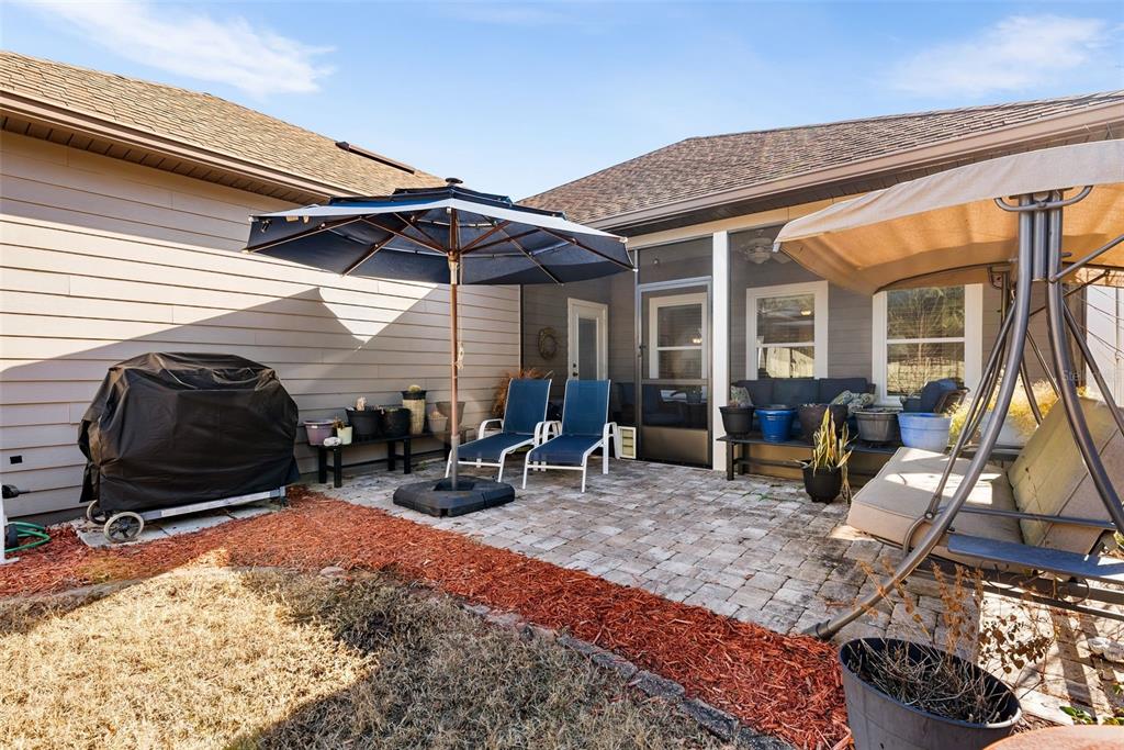 7638 Southwest 80th Drive Gainesville, FL 32608 - Photo 35 of 48 a view of a patio with table and chairs under an umbrella