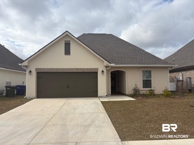 1371 Fenton Circle Foley, AL 36535 - Photo 1 of 3 View of front facade featuring driveway, a garage, stucco siding, and roof with shingles