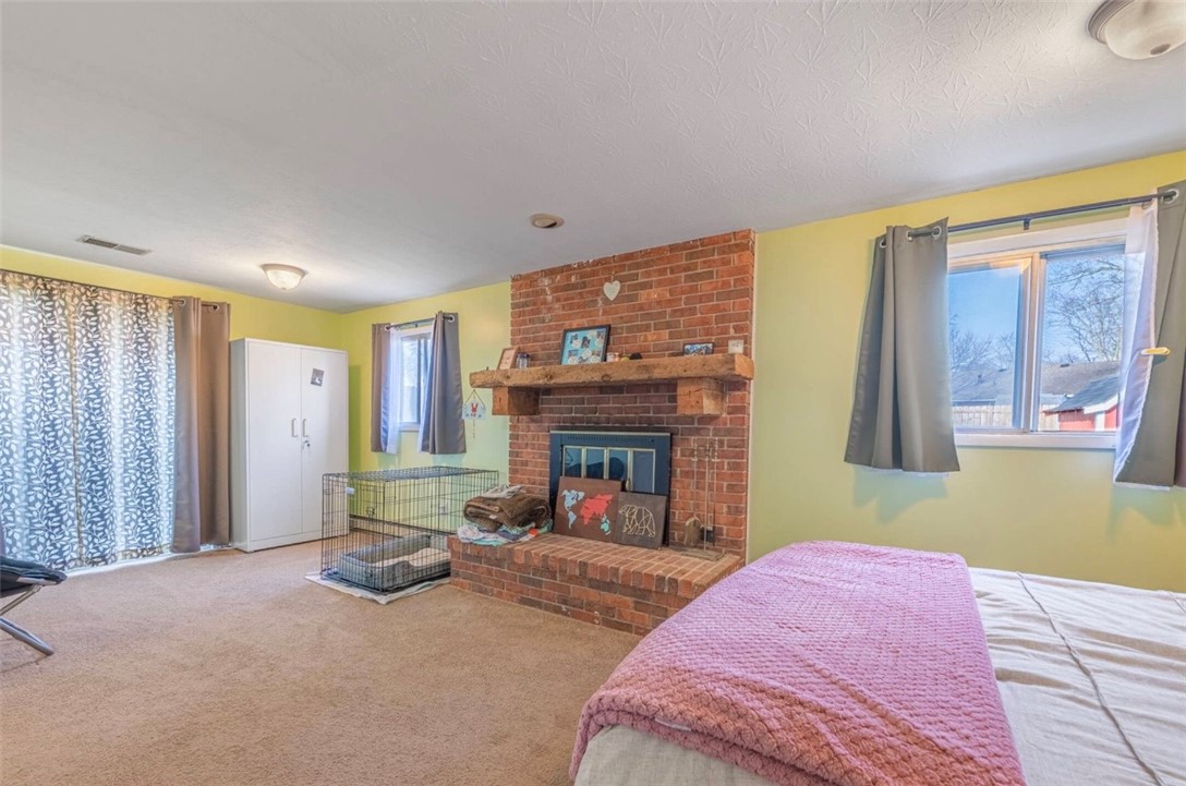 10 Monroe Road Lebanon, OH 45036 - Photo 8 of 14 This cozy bedroom features a traditional brick fireplace, perfect for warm and inviting evenings.