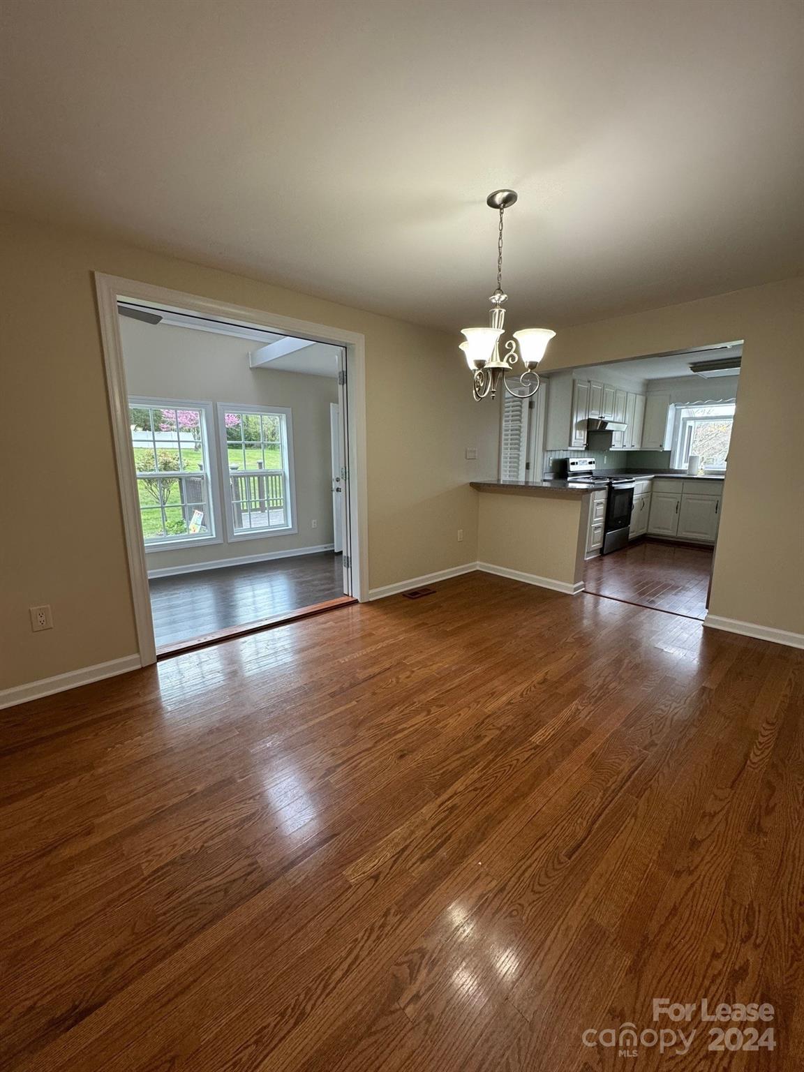 2793 Highway 268 Lenoir, NC 28645 - Photo 9 of 29 an empty room with wooden floor chandelier and windows