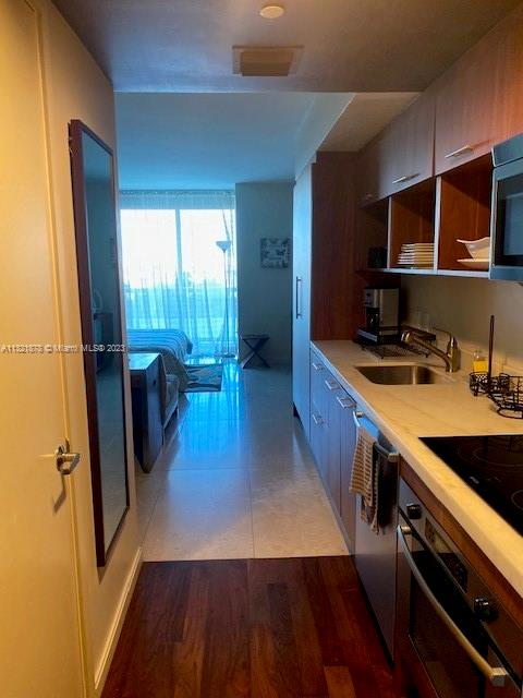 50 Biscayne Boulevard, Unit 709 Miami, FL 33132 - Photo 18 of 18 a kitchen with sink a refrigerator and wooden floor