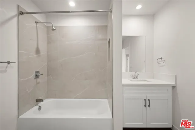 a bathroom with a bathtub a sink a vanity and a shower