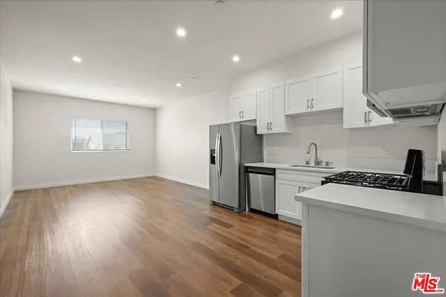 a kitchen with stainless steel appliances granite countertop a sink a stove a refrigerator and cabinets