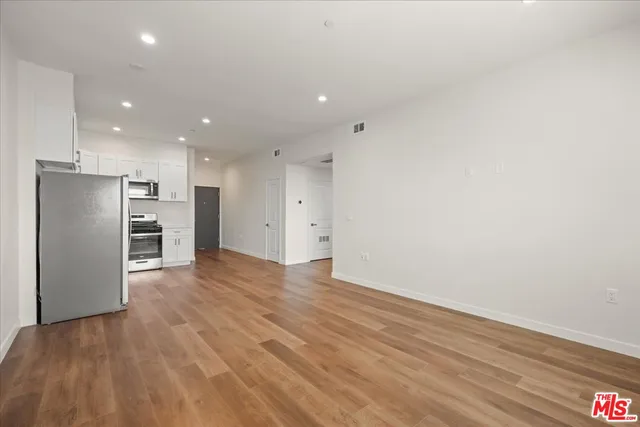 a view of a kitchen with a refrigerator and a stove top oven