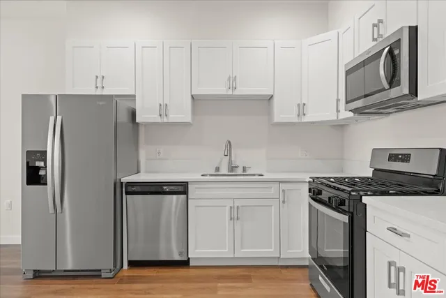 a kitchen with stainless steel appliances granite countertop white cabinets granite counter tops and a stove