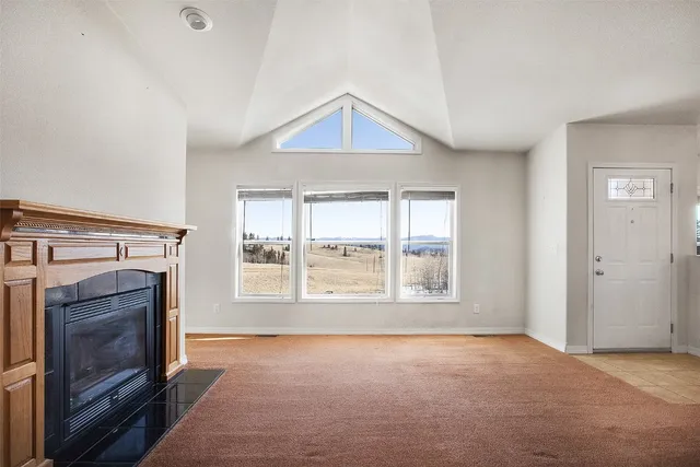 a view of an empty room with a fireplace and a window