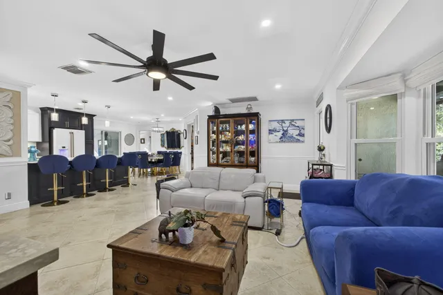 a dining room with wooden floor a chandelier a wooden table and chairs