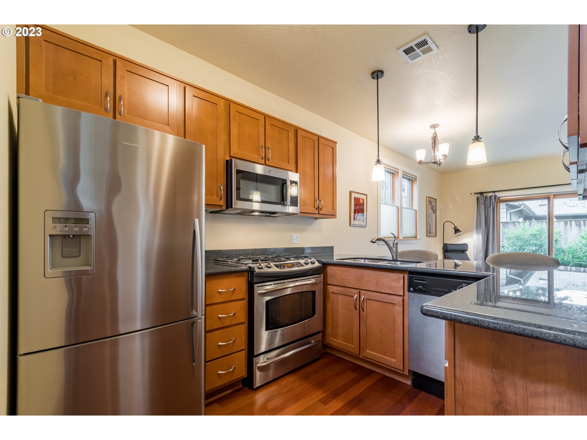 1410 Perdue Loop Eugene, OR 97401 - Photo 8 of 32 a kitchen with stainless steel appliances granite countertop a sink a stove a refrigerator a center island and cabinets