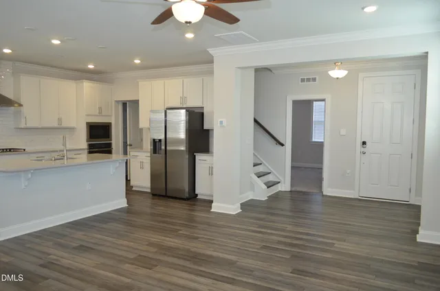 a view of a kitchen with wooden floor and a ceiling fan
