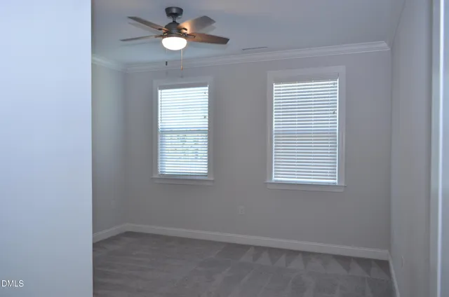 an empty room that has a window and a fan