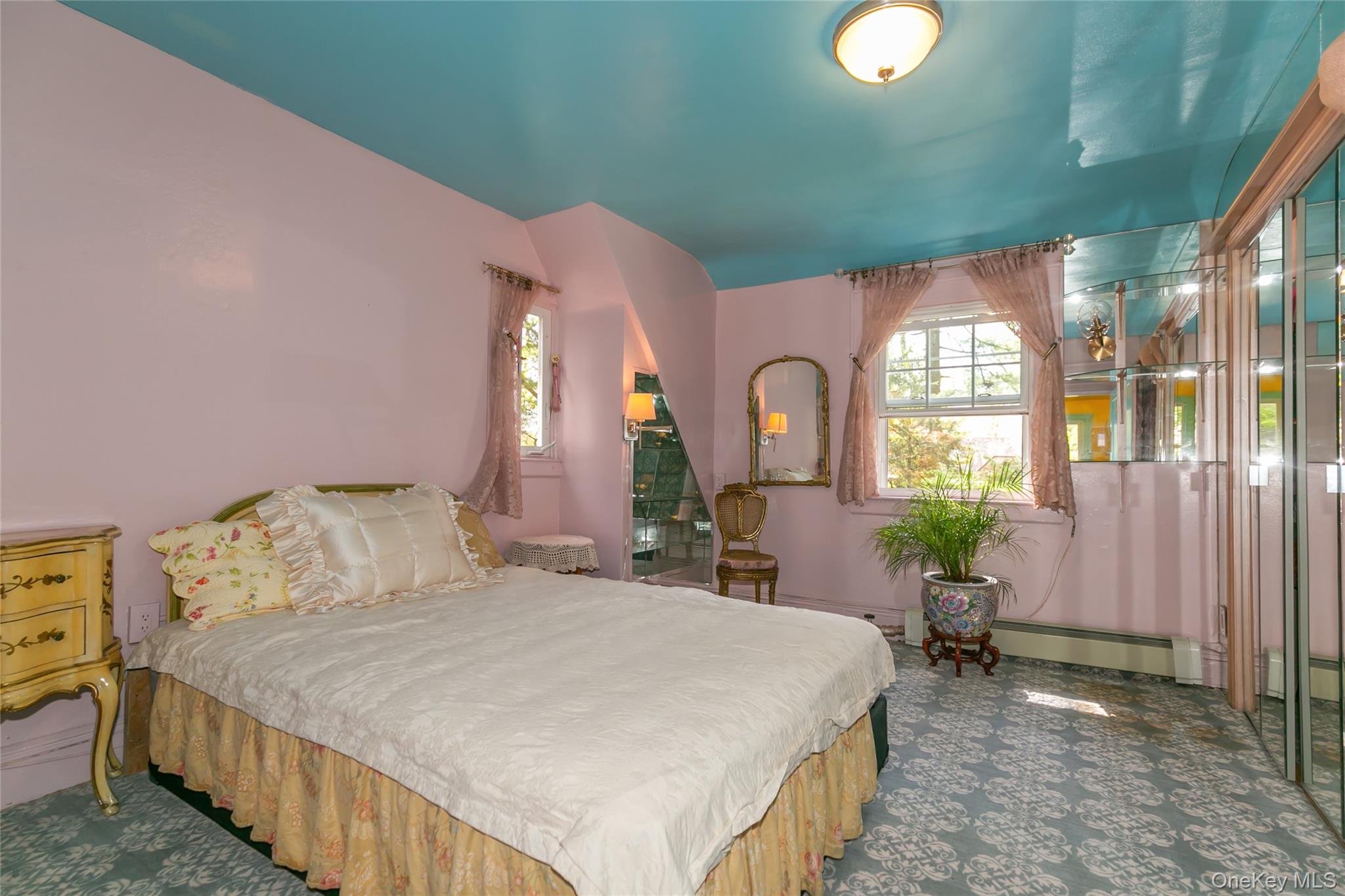 200 Myrtle Drive Great Neck, NY 11021 - Photo 17 of 25 a spacious bedroom with a bed table closet and a large window