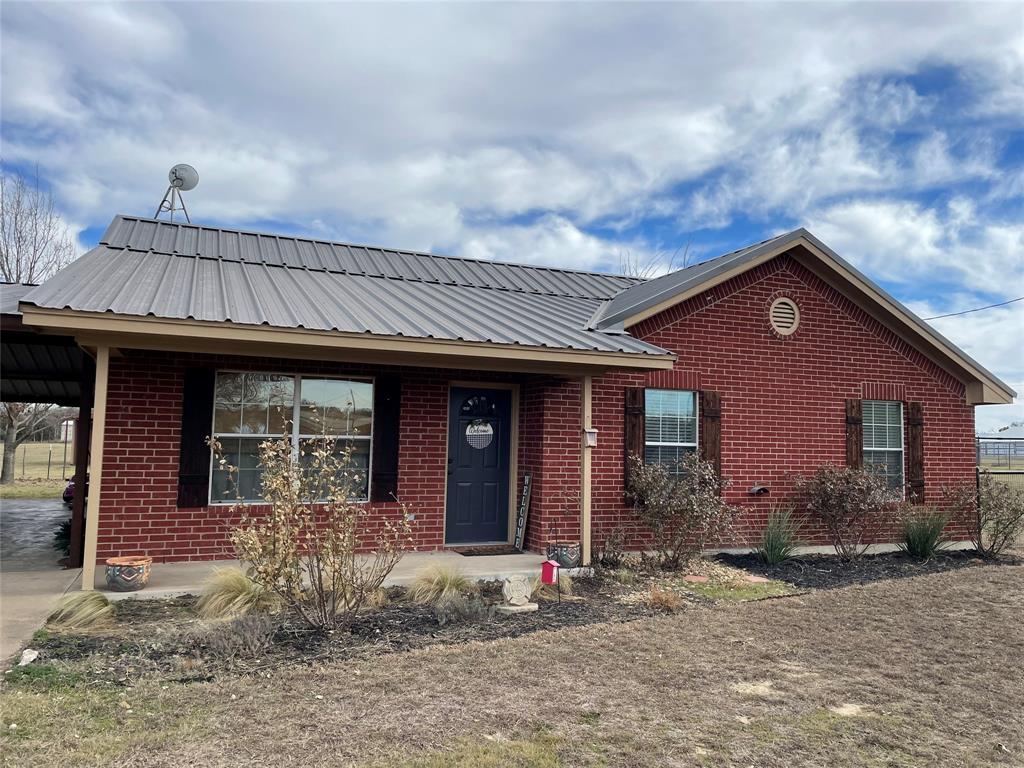 826 Gilliland Road Springtown, TX 76082 - Photo 1 of 1 a front view of a house with garden