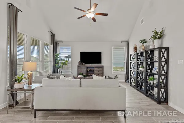 a living room with furniture a flat screen tv and a large window