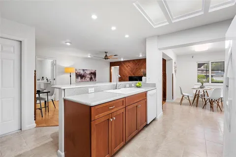 a living room with furniture kitchen view and a large window