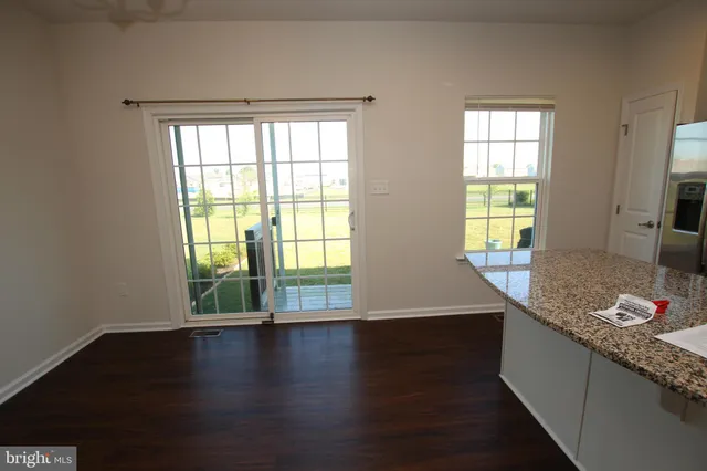 an empty room with wooden floor and a window