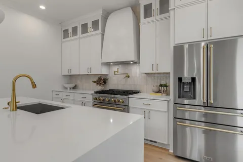 a kitchen with white cabinets and white appliances