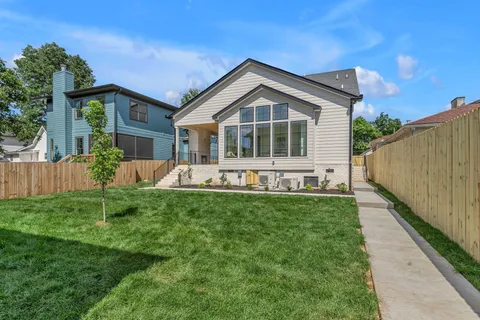 a kitchen with stainless steel appliances granite countertop white cabinets a microwave a sink and a refrigerator