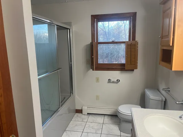 a bathroom with a toilet and a shower