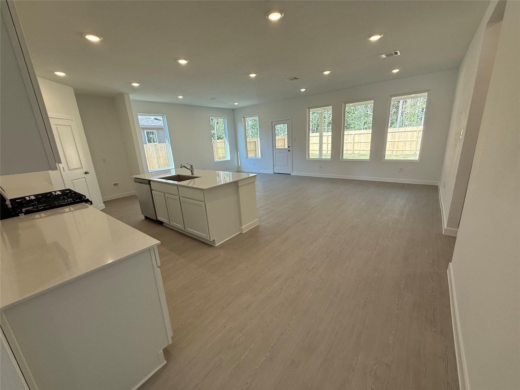 9315 Zander Drive Baytown, TX 77521 - Photo 6 of 21 a large white kitchen with stainless steel appliances granite countertop a stove a sink a refrigerator and white cabinets