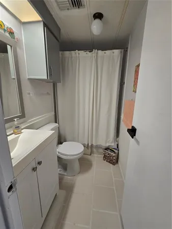 a bathroom with a sink a toilet a mirror and shower