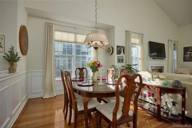 a dining room with furniture potted plants and wooden floor