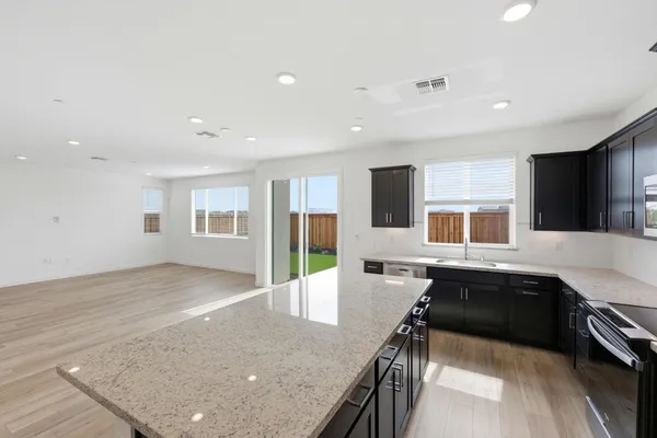 a large kitchen with kitchen island a sink table and chairs