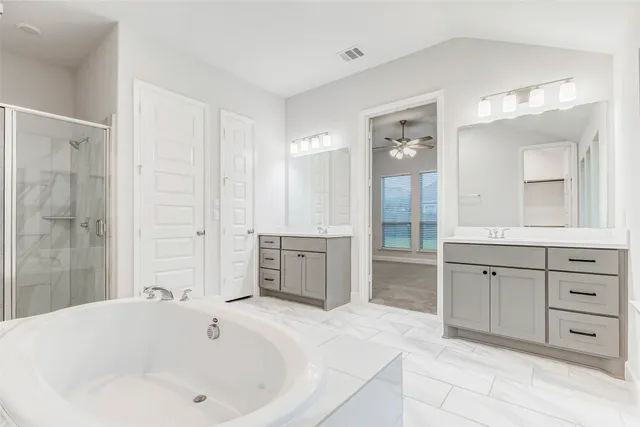 a spacious bathroom with a tub sink and mirror