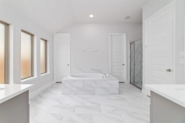 a spacious bathroom with a tub shower and sink