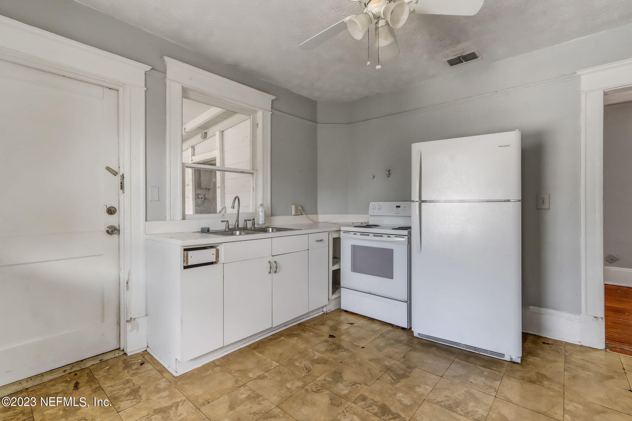 2805 College Street Jacksonville, FL 32205 - Photo 29 of 40 a kitchen with white cabinets and white appliances