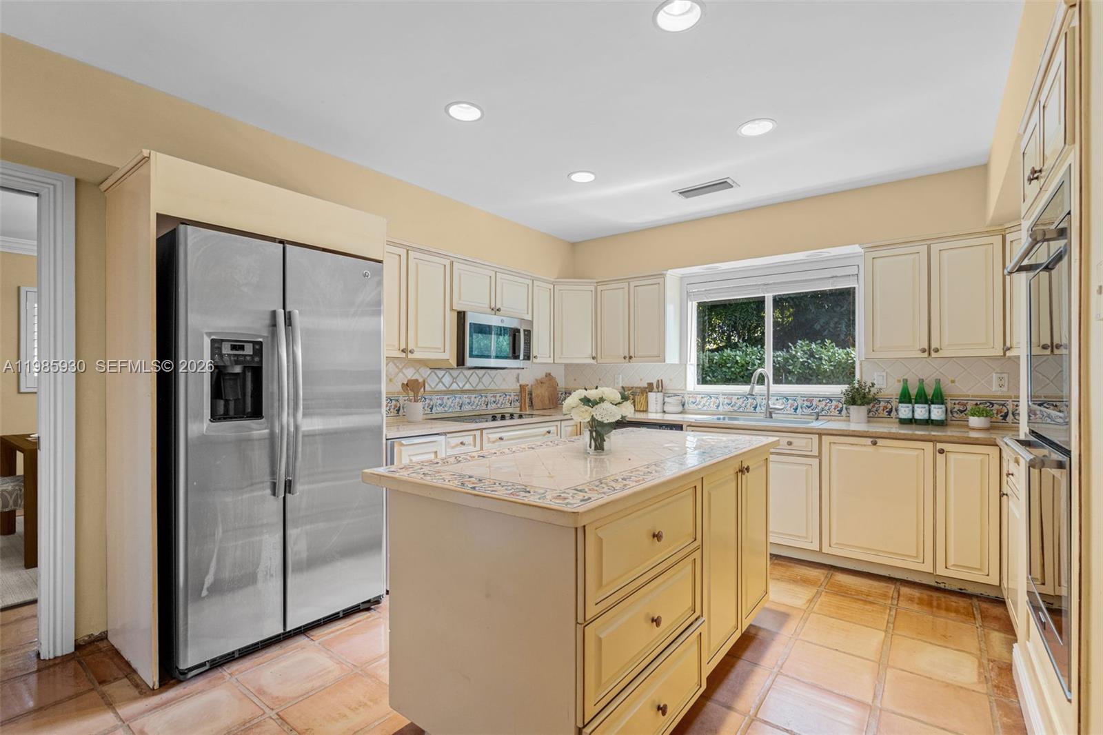 13276 Southwest 58th Court Pinecrest, FL 33156 - Photo 22 of 67 a kitchen with white cabinets and refrigerator