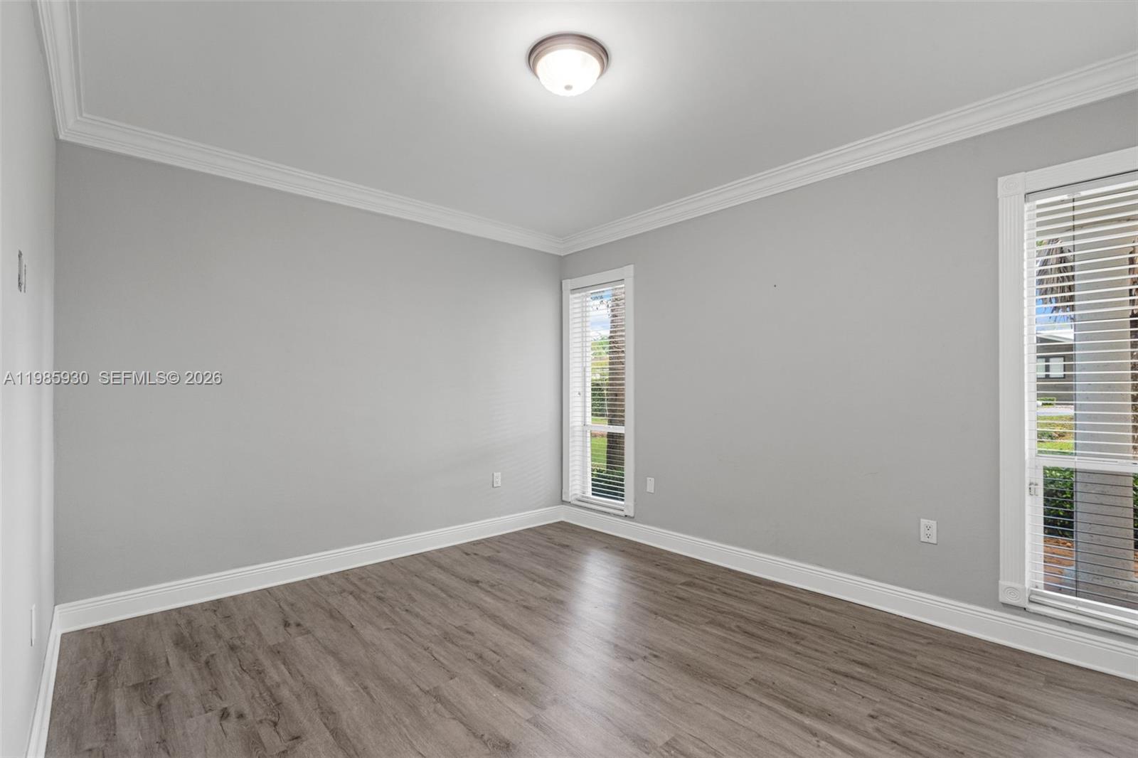13276 Southwest 58th Court Pinecrest, FL 33156 - Photo 29 of 67 an empty room with wooden floor and windows