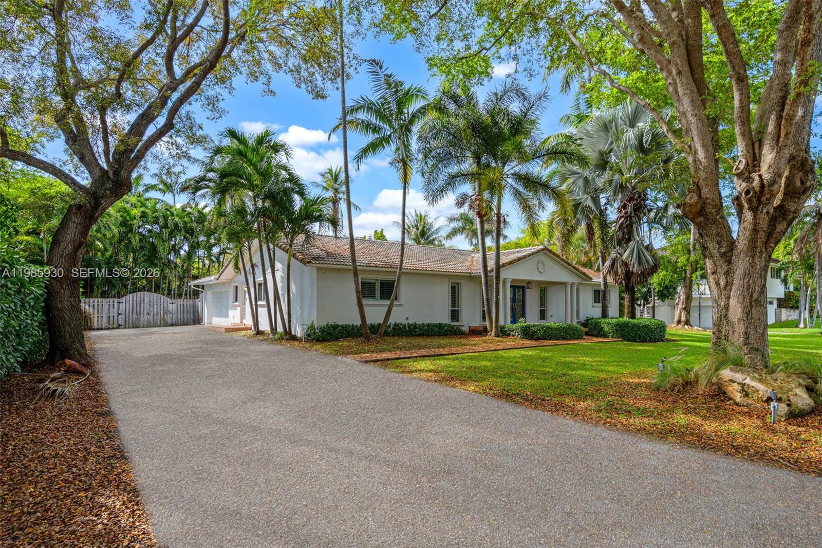 13276 Southwest 58th Court Pinecrest, FL 33156 - Photo 3 of 67 a front view of a house with a garden and trees