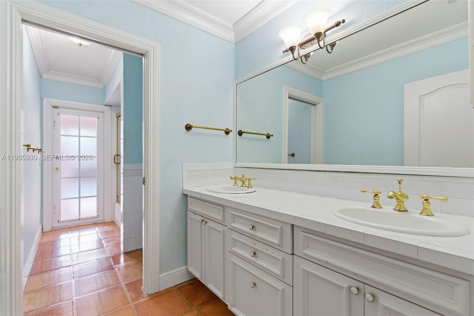 13276 Southwest 58th Court Pinecrest, FL 33156 - Photo 32 of 67 a bathroom with a sink and a mirror