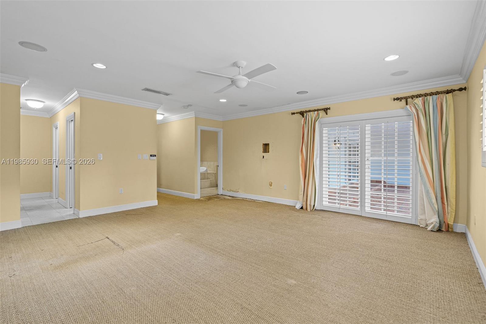 13276 Southwest 58th Court Pinecrest, FL 33156 - Photo 41 of 67 an empty room with windows and a ceiling fan
