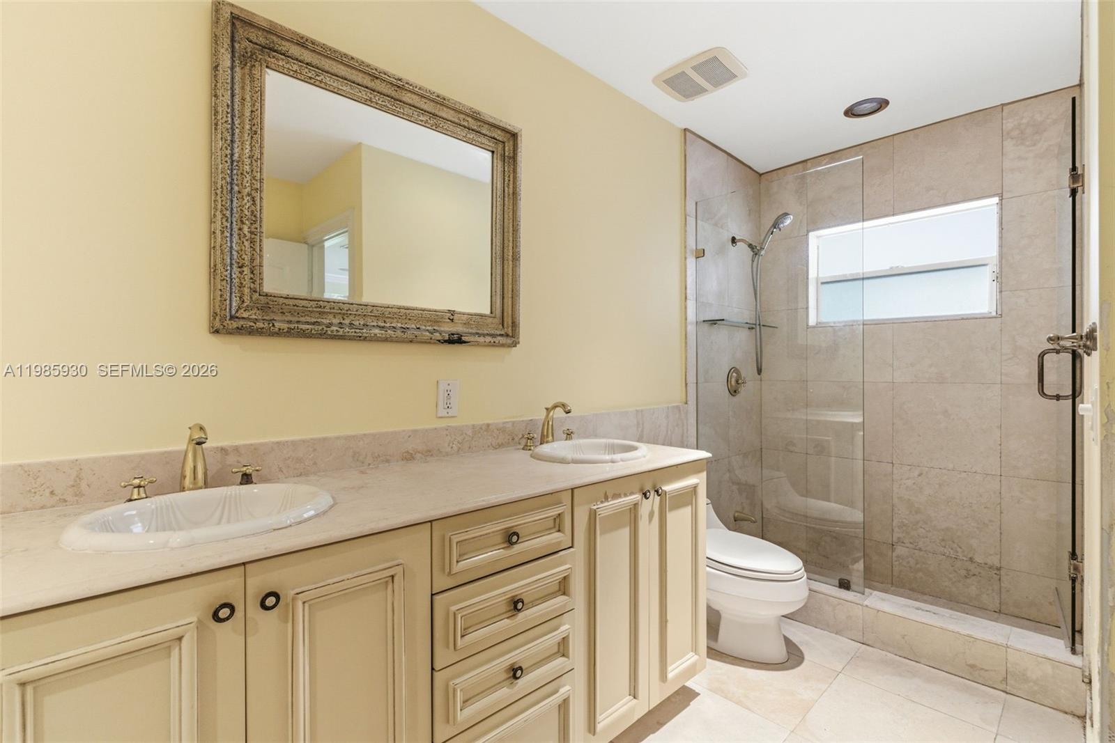 13276 Southwest 58th Court Pinecrest, FL 33156 - Photo 47 of 67 a bathroom with a toilet sink vanity and mirror