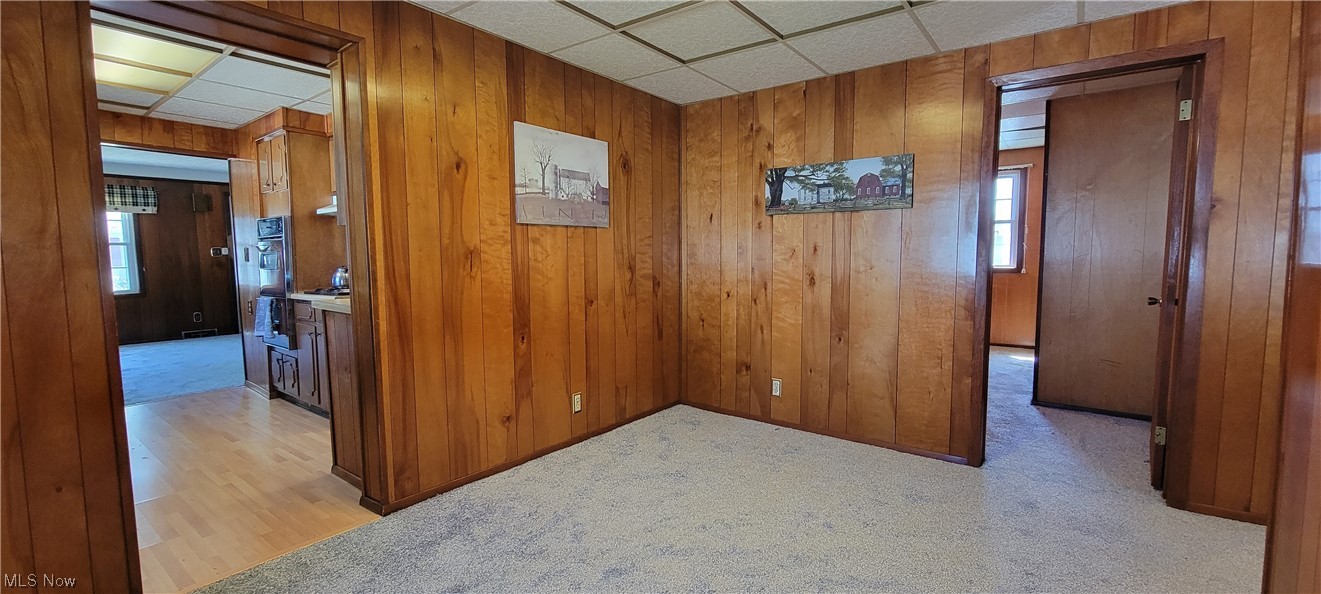 33703 Guilbert Road Eastlake, OH 44095 - Photo 24 of 32 Corridor with wood walls, a drop ceiling, and light hardwood floors