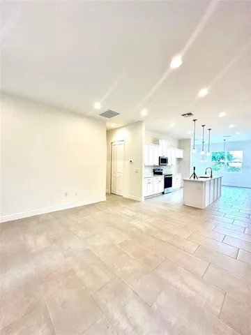 a view of open kitchen with kitchen island a sink a stove and a refrigerator
