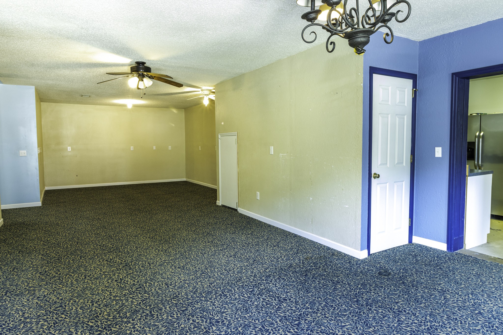 124 Chestnut Street Pulaski, TN 38478 - Photo 3 of 33 an empty room with a chandelier fan and wooden floor
