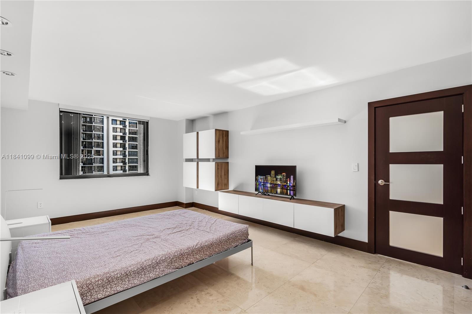 540 Brickell Key Drive, Unit 1021 Miami, FL 33131 - Photo 13 of 30 a spacious bedroom with a bed and a window
