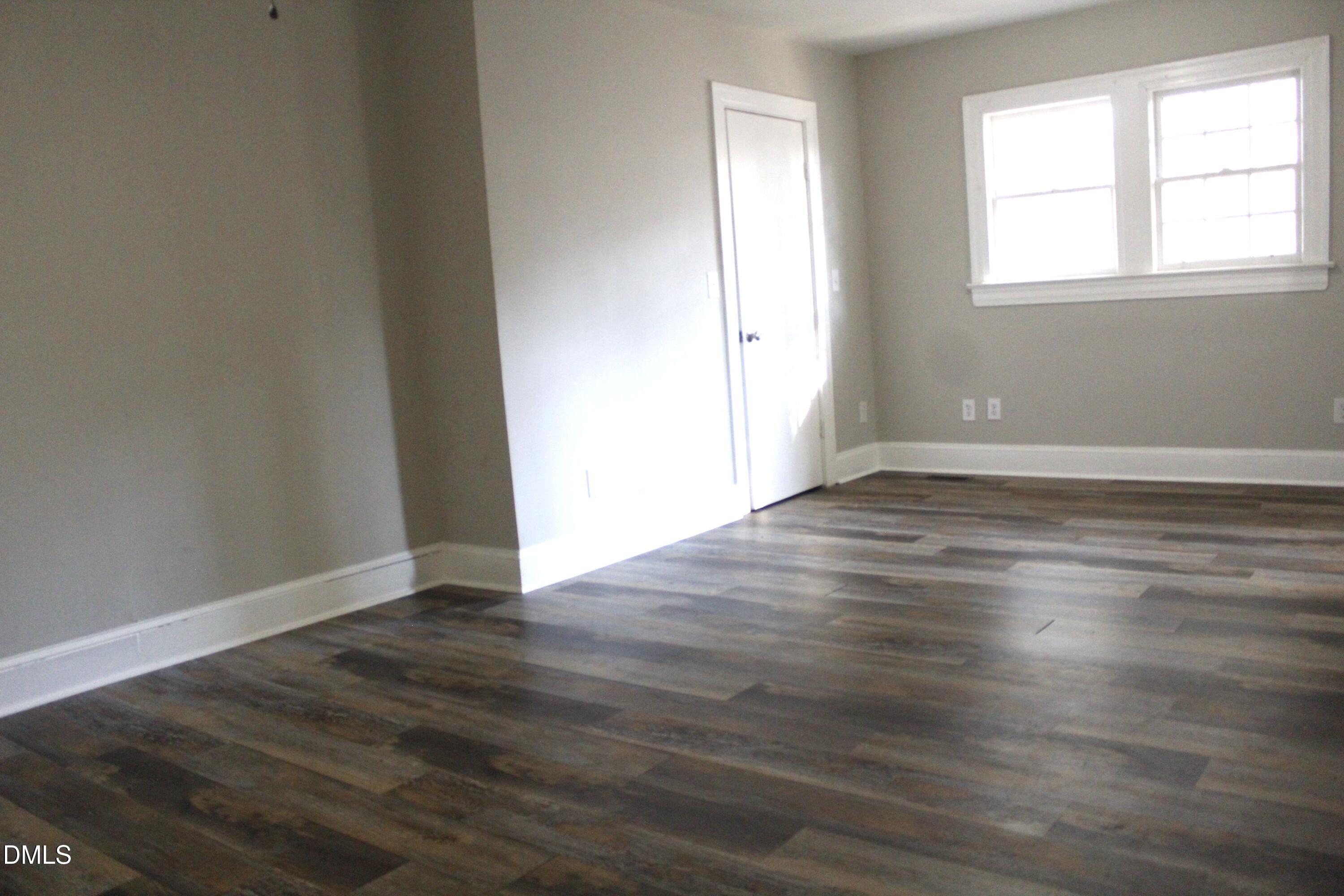 907 Leggett Road Rocky Mount, NC 27801 - Photo 16 of 23 an empty room with wooden floor and windows