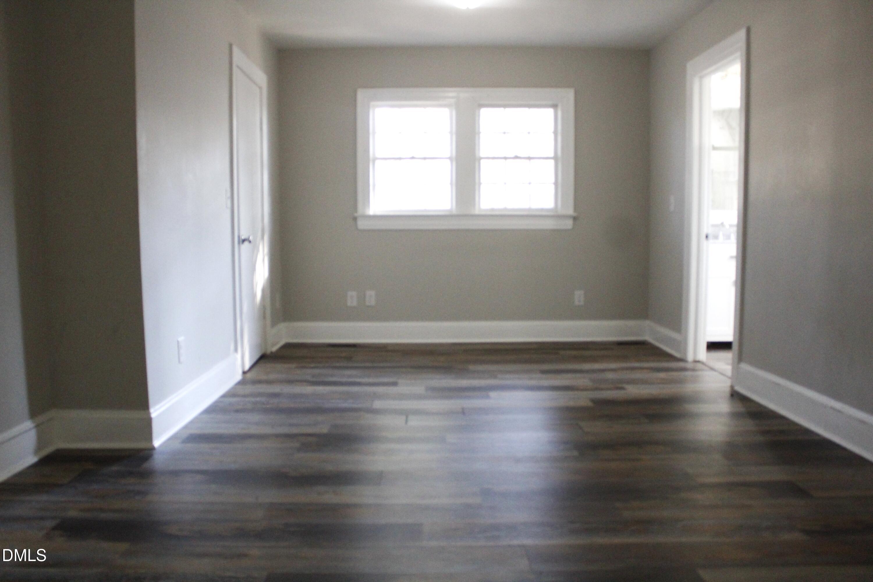 907 Leggett Road Rocky Mount, NC 27801 - Photo 17 of 23 an empty room with wooden floor and windows