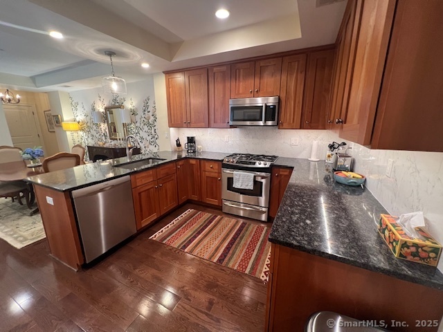 103 Main Street, Unit 2202 Stonington, CT 06378 - Photo 4 of 29 a kitchen with stainless steel appliances granite countertop wooden cabinets a stove top oven a sink and dishwasher